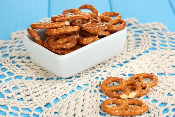 Saborosos pretzels em tigela branca e jarro de leite em mesa de madeira close-up — Fotografia de Stock