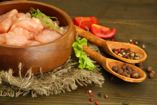 Raw chicken meat in bowl, on wooden background — Stock Photo, Image