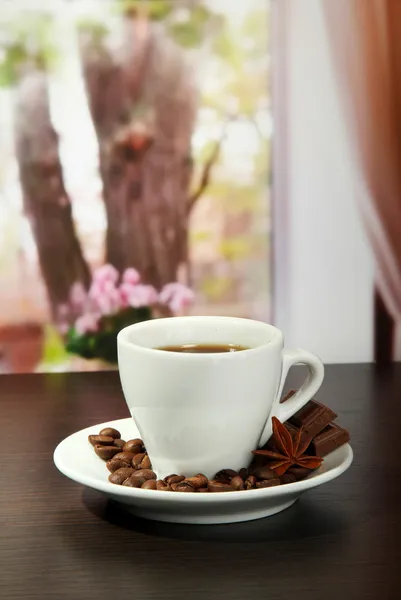 Xícara de café com grãos na mesa no café — Fotografia de Stock