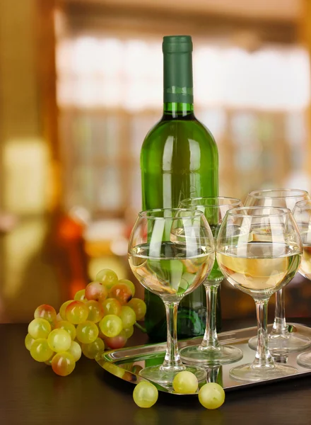 Vino bianco in vetro e bottiglia su sfondo camera — Foto Stock