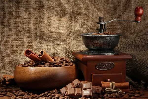 Kávédaráló és kávét a zsákvászon háttér — Stock Fotó