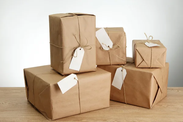 Cajas de paquetes con papel kraft, sobre mesa de madera sobre fondo gris —  Fotos de Stock