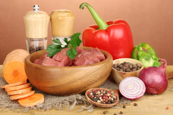 Viande de bœuf crue marinée aux herbes et épices sur table en bois sur fond brun — Photo