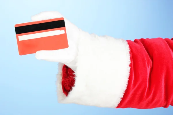 Santa Claus hand holding red credit card on blue background — Stock Photo, Image