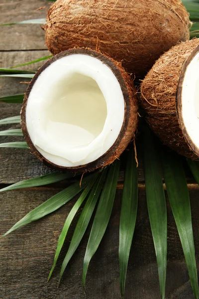 Noce di cocco con foglie, su fondo grigio in legno — Foto Stock