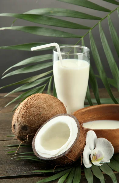 Kokos met glas melk, op houten tafel, op grijze achtergrond — Stockfoto