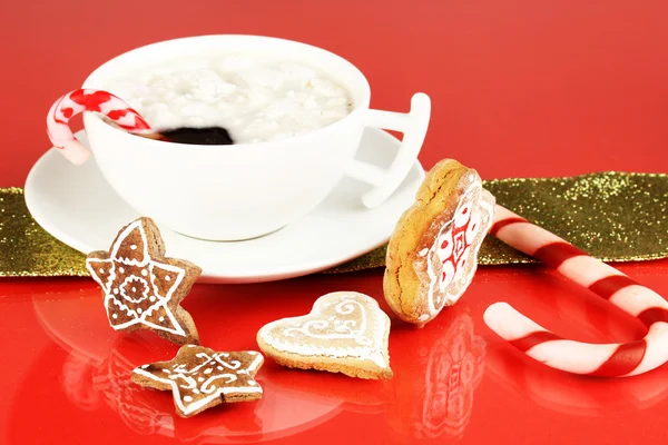 Cup of coffee with Christmas sweetness on red background — Stock Photo, Image