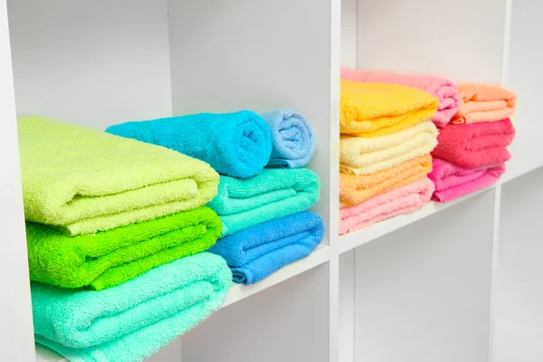 Colorful towels on shelves in bathroom — Stock Photo, Image