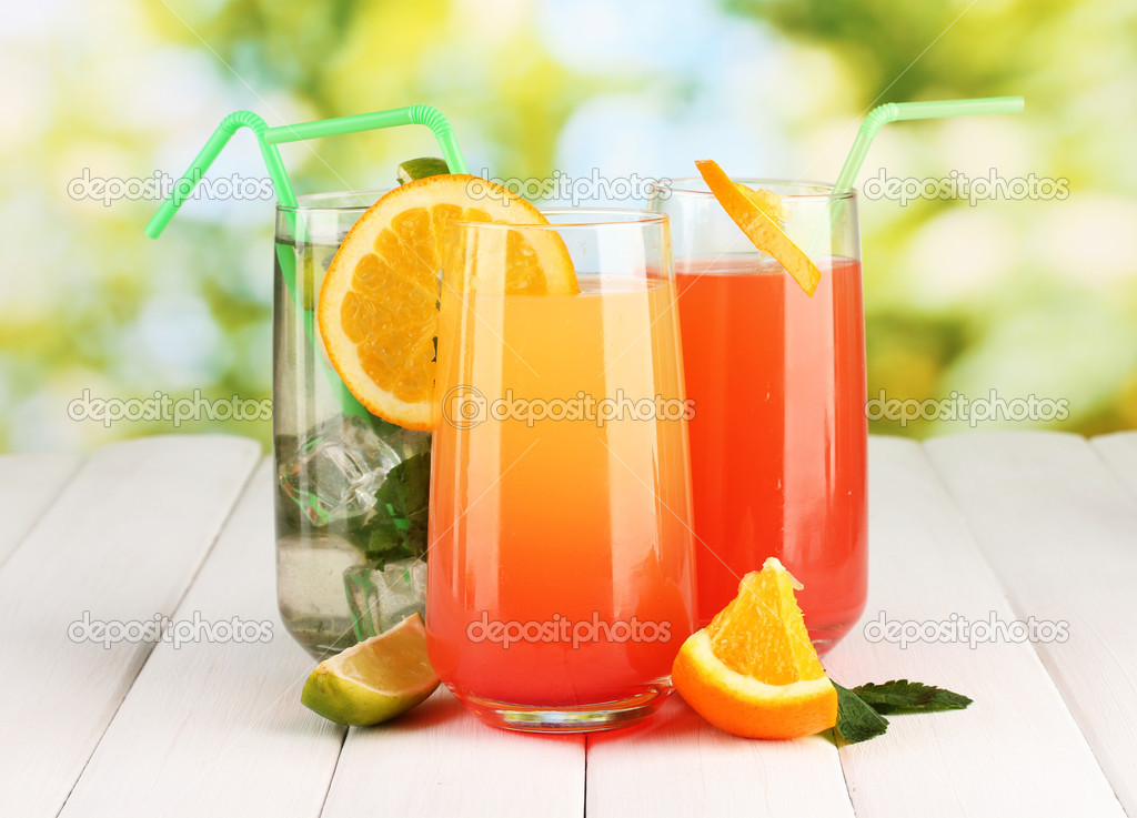 Three cocktails on wooden table on bright background