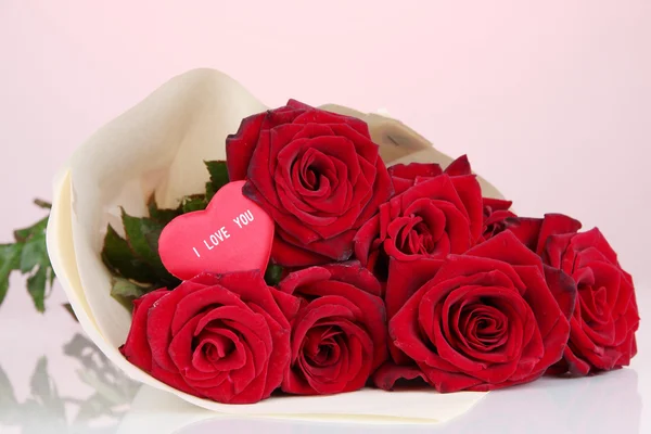 Beautiful bouquet of red roses with valentine on red background — Stock Photo, Image