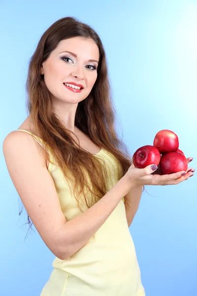 Elma mavi zemin üzerine ile güzel bir kadın — Stok fotoğraf