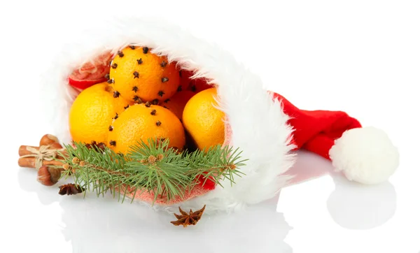Weihnachtskomposition mit Orangen und Tanne in Weihnachtsmannmütze, isoliert auf weiß — Stockfoto