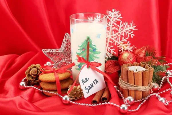 Cookies para Santa: Imagem conceitual de biscoitos de gengibre, leite e decoração de Natal em fundo vermelho — Fotografia de Stock