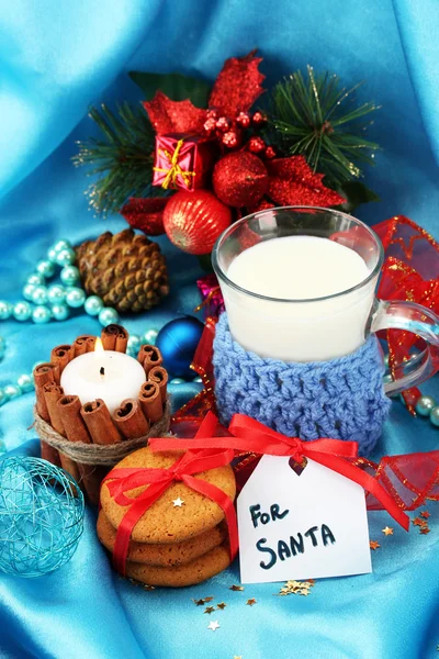 Cookies for Santa: Conceptual image of ginger cookies, milk and christmas decoration on blue background — Stock Photo, Image