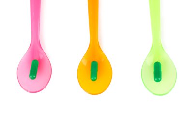 plastik kaşık ile üzerine beyaz izole renkli hapları