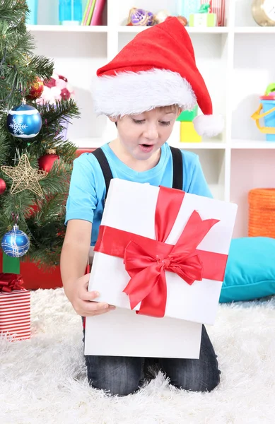 小さな男の子クリスマスの木の近くの彼の贈り物を開く — ストック写真