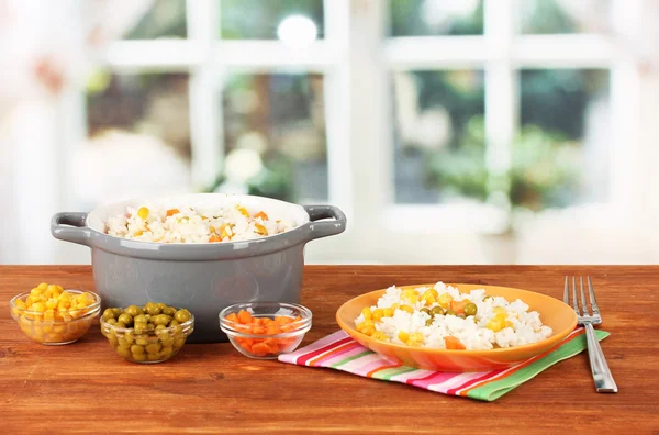 Risotto en maceta gris sobre mesa de madera sobre fondo brillante — Foto de Stock