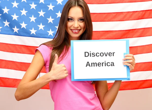 Jovem mulher jovem segurando tablet no fundo da bandeira americana — Fotografia de Stock