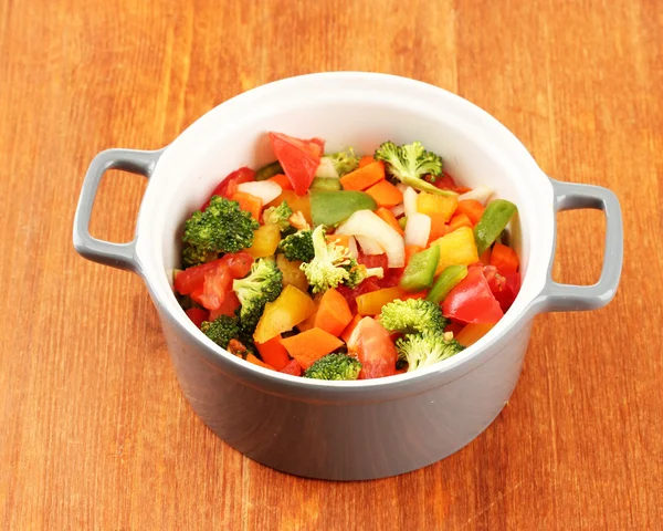 Ragoût de légumes en pot gris sur fond bois — Photo