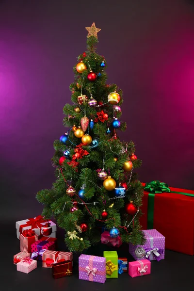 Geschmückter Weihnachtsbaum mit Geschenken auf dunklem Hintergrund — Stockfoto