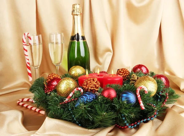 Прекрасний різдвяний вінок в композиції з шампанським на фоні золотої тканини — стокове фото