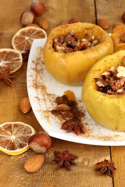 Manzanas al horno en plato sobre mesa de madera —  Fotos de Stock