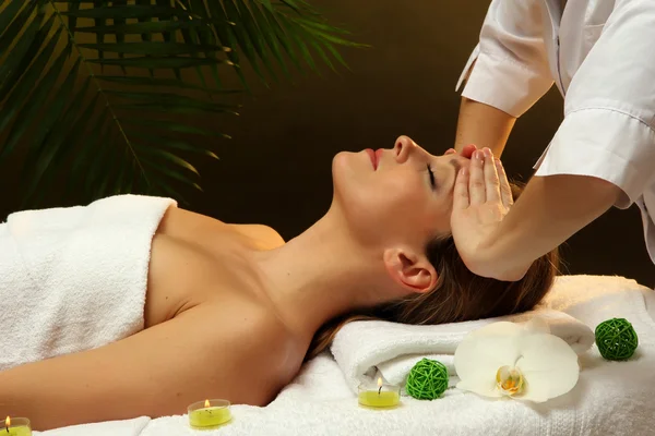 Portrait of beautiful woman taking head massage on green background — Stock Photo, Image
