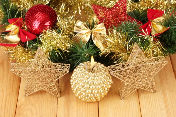 Kerstmis samenstelling met kaarsen en decoraties in rode en gouden kleuren op houten achtergrond — Stockfoto