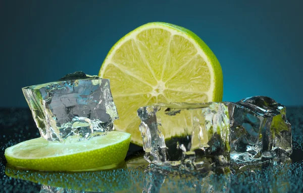 Ice cubes with lime on darck blue background — Stock Photo, Image