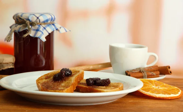 Biały chleb tosty z dżemem i filiżankę kawy na drewnianym stole — Zdjęcie stockowe