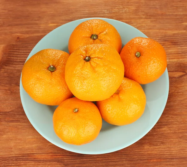 Chutné mandarinky barevné desky na dřevěné pozadí — Stock fotografie