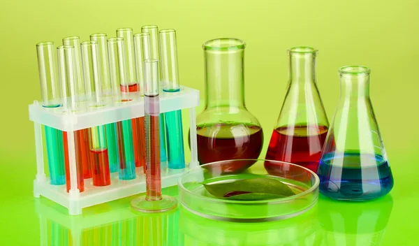 Petri dish, renkli arka plan üzerinde test tüpleri ve yeşil yaprak test — Stok fotoğraf