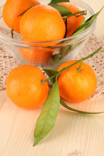 Sweet tangerines with leaves, on wooden background — Stock Photo, Image