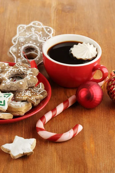 Weihnachtsleckereien auf Teller und Tasse Kaffee auf Holztisch in Großaufnahme — Stockfoto