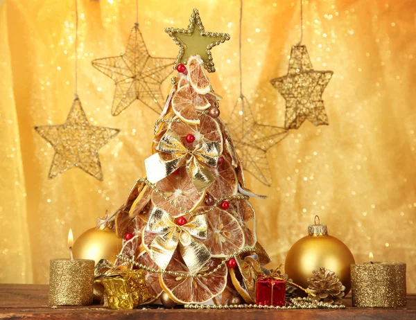 Schöner Weihnachtsbaum aus trockenen Zitronen mit Dekor, auf gelbem Hintergrund — Stockfoto