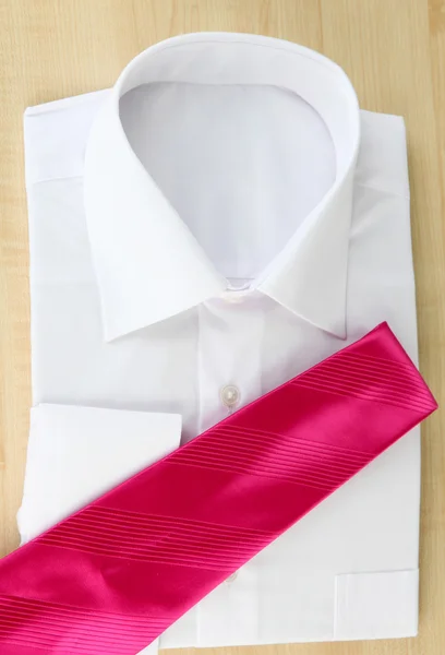 New white man's shirt with color tie on wooden background — Stock Photo, Image