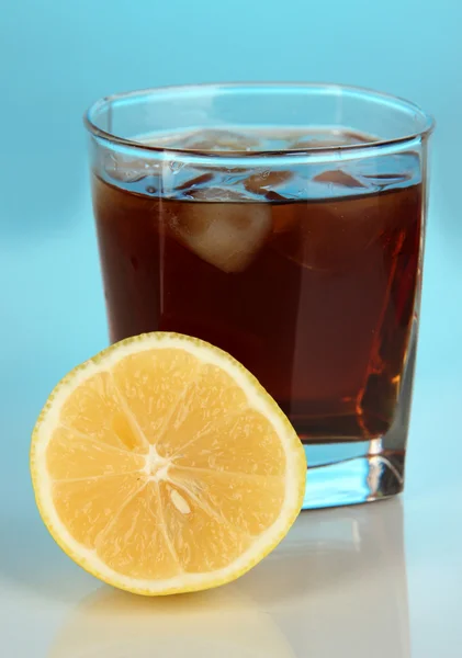 Verre de whisky avec glace et citron sur fond bleu — Photo