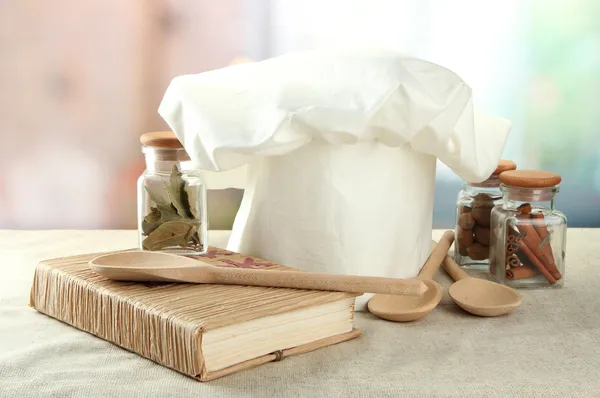 Chef's hat with spoons on table in kitchen — Stock Photo, Image