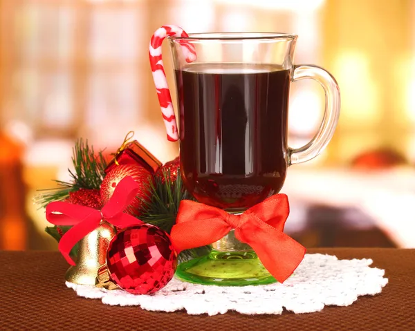 Heißes leckeres Getränk mit Weihnachtsbonbons und anderen Dekorationen auf hellem Hintergrund — Stockfoto