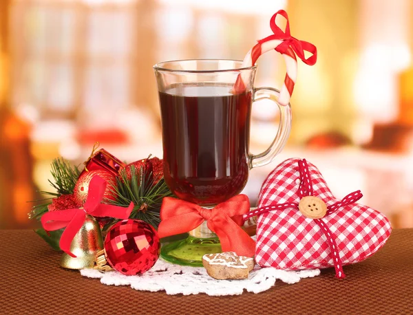 Hot tasty drink with christmas candy and other decorations on bright background — Stock Photo, Image