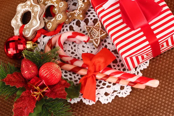 Composizione natalizia con caramelle, biscotti e decorazioni natalizie su sfondo marrone — Foto Stock