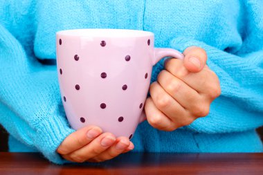 yakın çekim sıcak bir fincan tutan eller iç