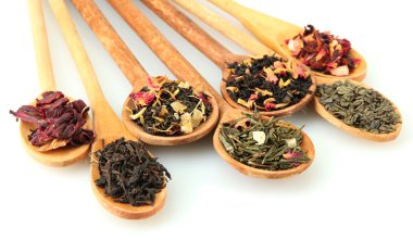 assortment of dry tea in spoons, isolated on white clipart