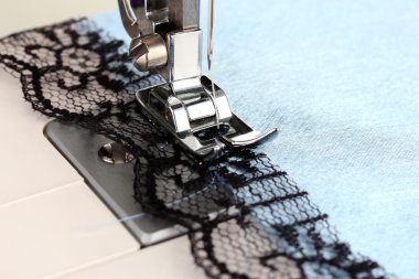 closeup dikiş makinesi çalışma bölümü mavi bir bez ile