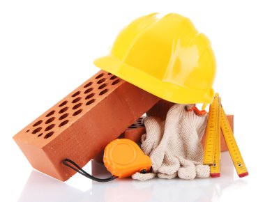 kask, rulet, tuğla ve üzerinde beyaz izole eldivenler