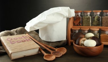 Şef'in şapkası ve kitchenwear tabloda gri arka plan üzerinde kompozisyonu