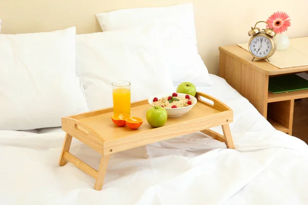 Holztablett mit leichtem Frühstück auf dem Bett — Stockfoto