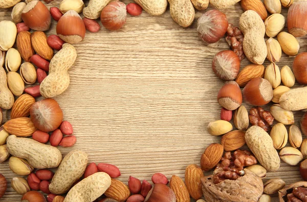 Assortment of tasty nuts on wooden background — Stock Photo, Image