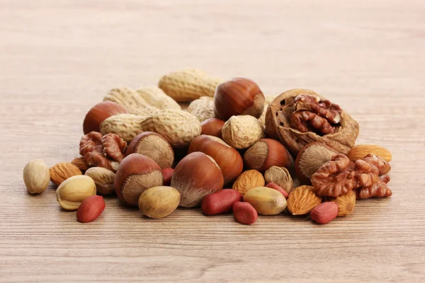 Auswahl an leckeren Nüssen auf Holzgrund — Stockfoto