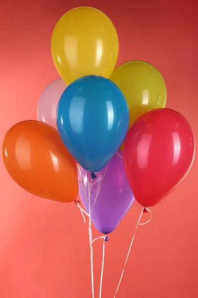 Balões coloridos no fundo vermelho — Fotografia de Stock